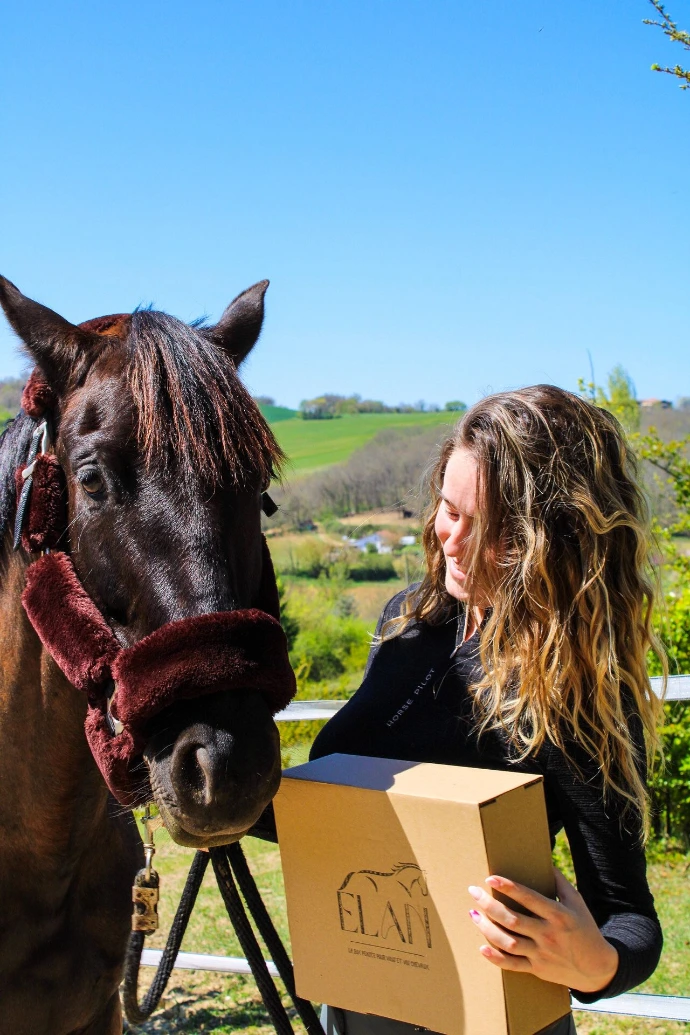 Cavalière tenant sa box ÉLAN avec son cheval - box équestre mensuelle